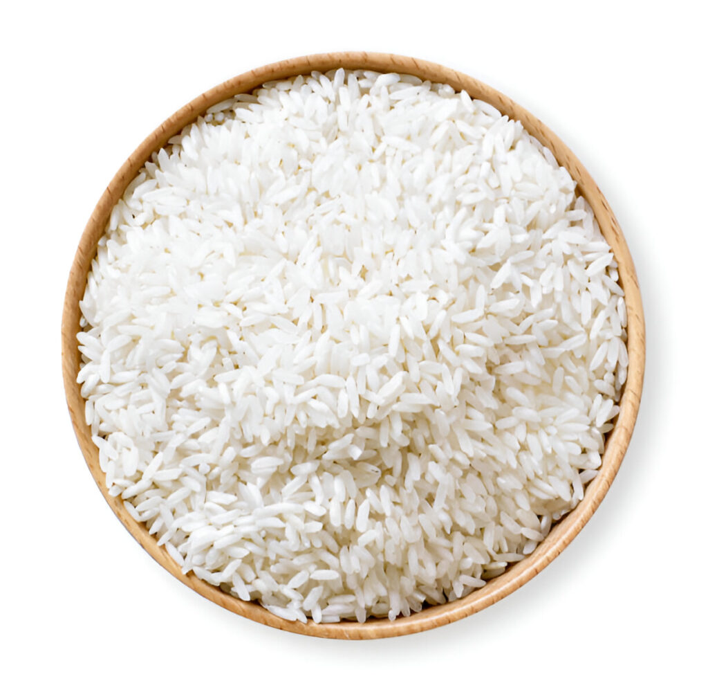 Yellow-tinted parboiled rice spread on a wooden surface